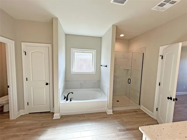 a spacious bathroom with a tub shower and closet