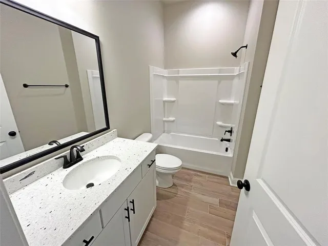 a bathroom with a sink a toilet a mirror and shower