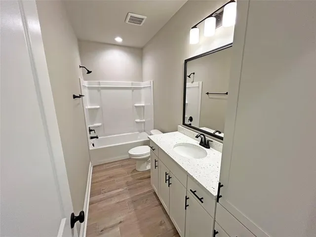 a bathroom with a double vanity sink toilet mirror and shower