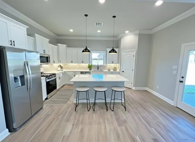 a kitchen with a table chairs refrigerator microwave and cabinets