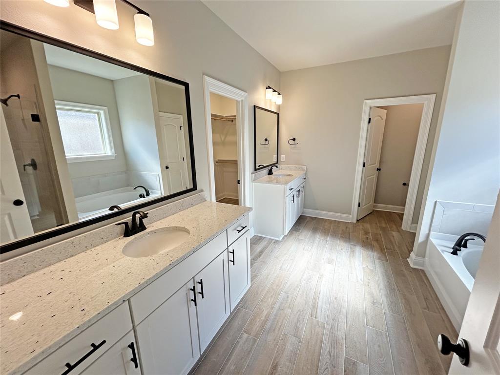 405 Merestone Crossing Benton, LA 71006 - Photo 10 of 22 a spacious bathroom with a double vanity sink a mirror and wooden floor