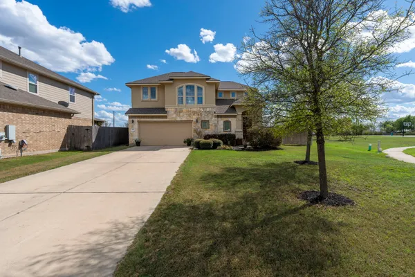 a front view of a house with yard and green space