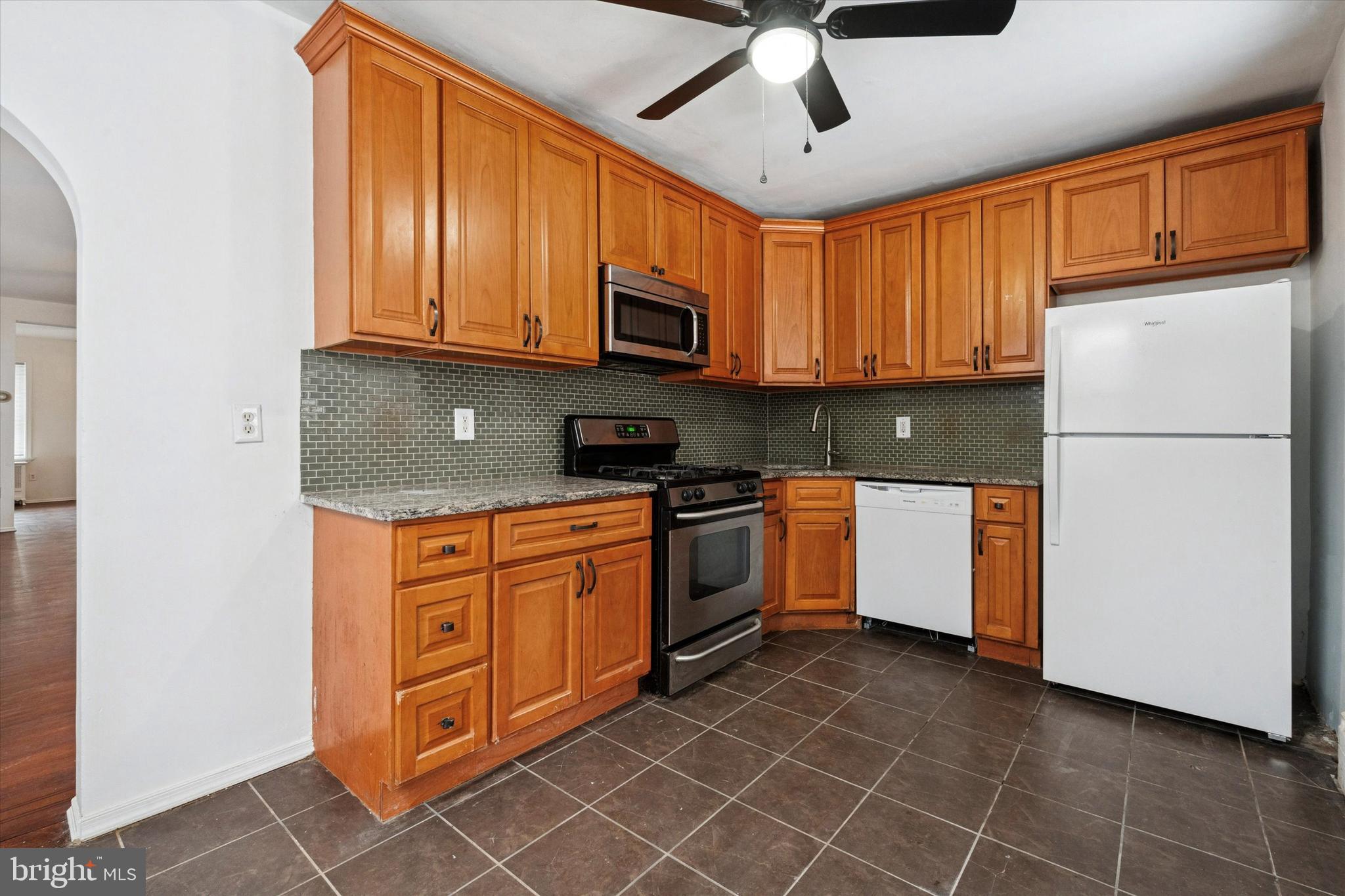 4489 Livingston Street Philadelphia, PA 19137 - Photo 9 of 25 a kitchen with stainless steel appliances granite countertop a refrigerator a stove top oven a sink and dishwasher