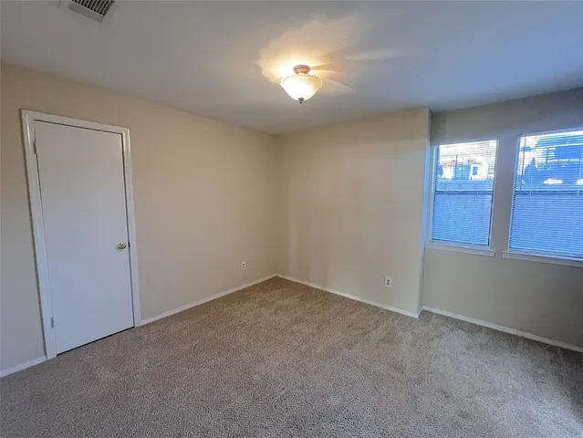a view of an empty room with window and stairs
