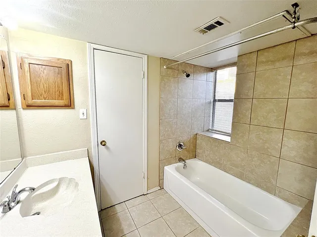 a bathroom with a tub shower and a sink