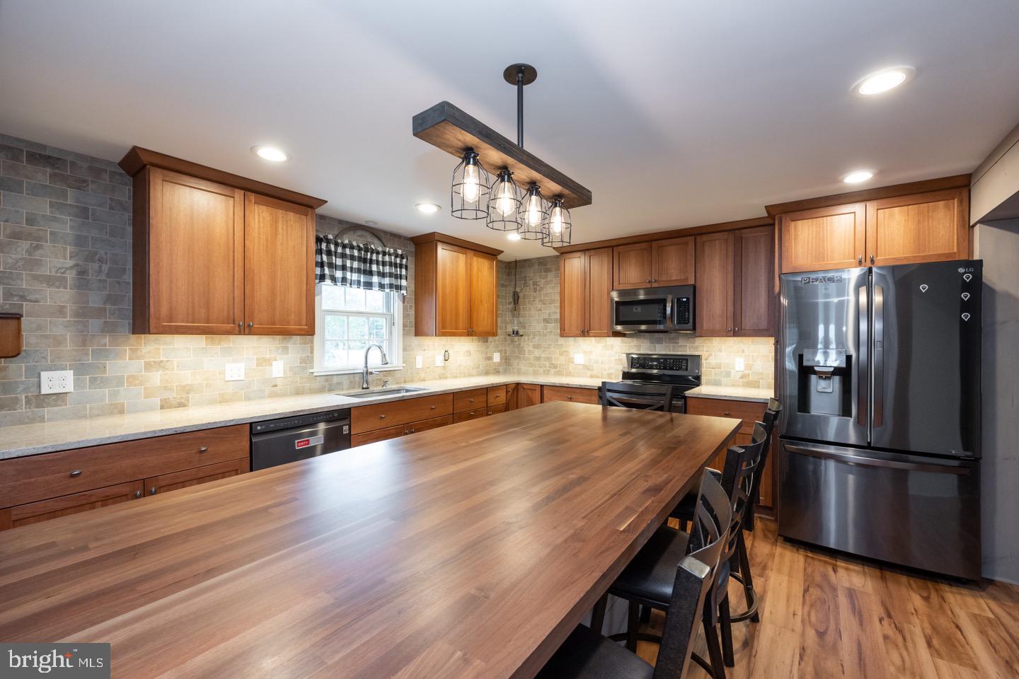4221 Blair Mill Road Hatboro, PA 19040 - Photo 11 of 42 a kitchen with granite countertop a refrigerator a sink dishwasher a stove and white cabinets with wooden floor