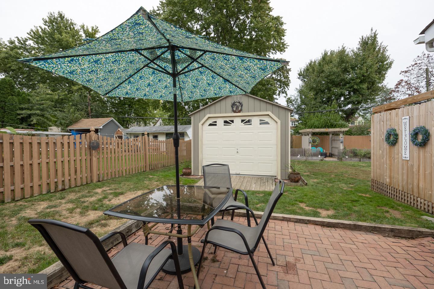 4221 Blair Mill Road Hatboro, PA 19040 - Photo 40 of 42 a patio with a table and chairs under an umbrella