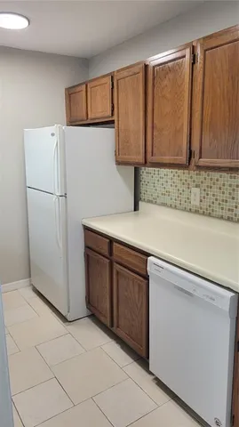a kitchen with a refrigerator sink and cabinets