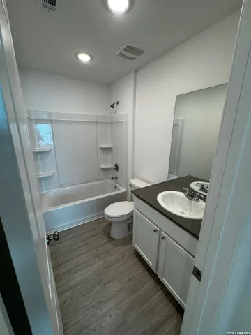 a view of a hallway with wooden floor and closet area