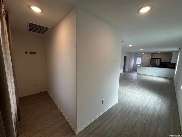 a view of a hallway with wooden floor