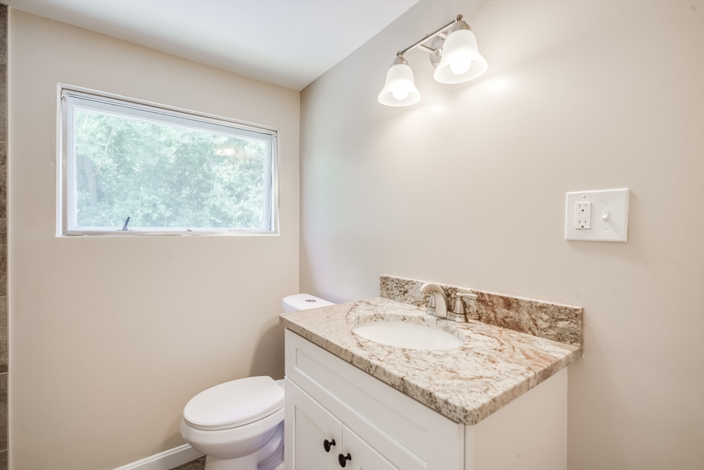 56 Audley Road Springfield, MA 01118 - Photo 23 of 37 a bathroom with a granite countertop sink a toilet and a window