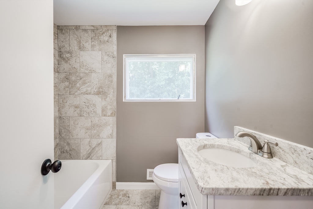 56 Audley Road Springfield, MA 01118 - Photo 9 of 37 a bathroom with a granite countertop sink a toilet and bathtub