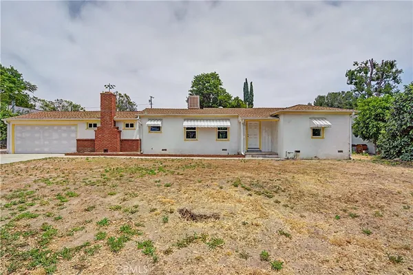 a view of a house with backyard and garden