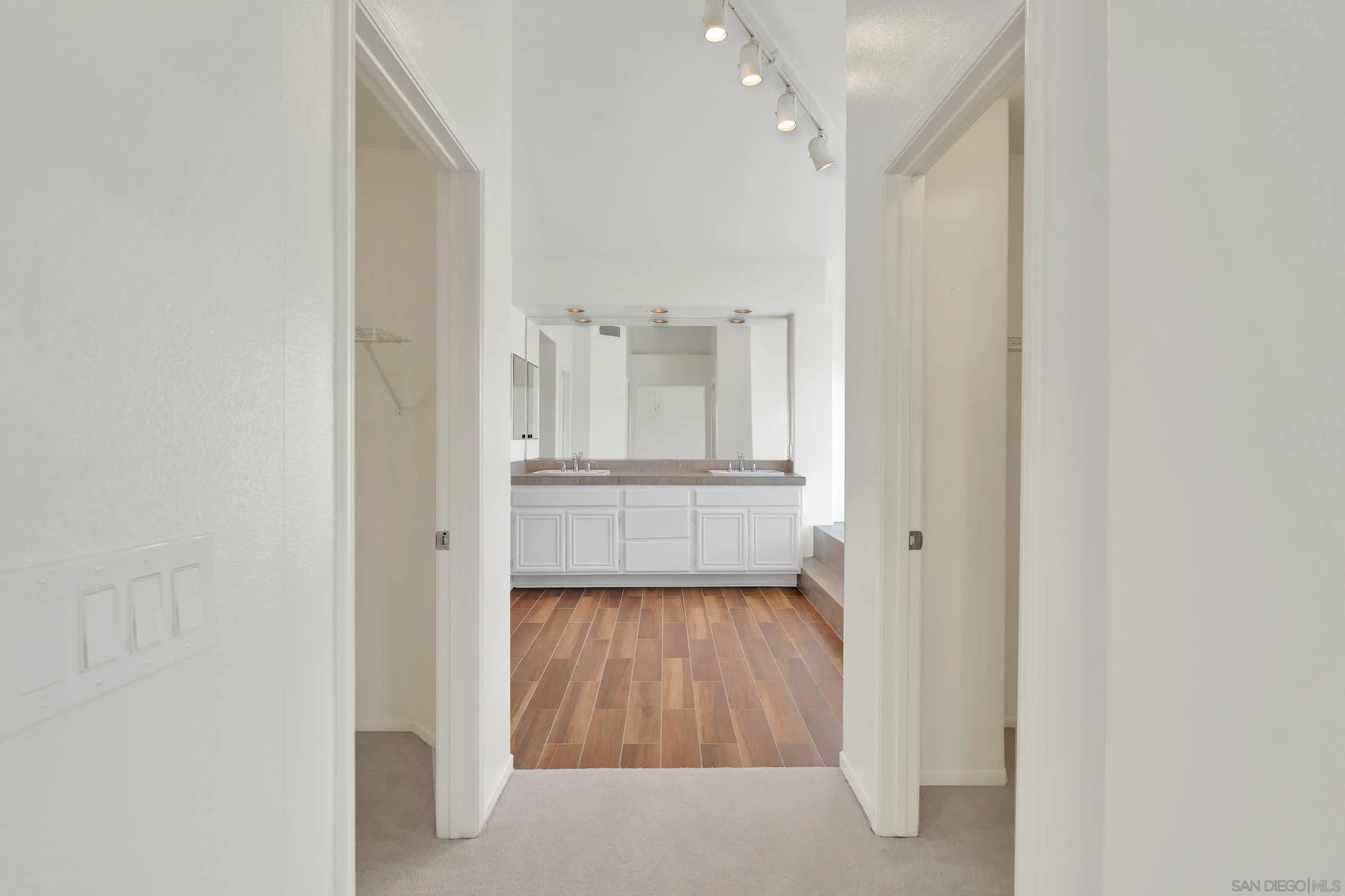 45441 Camino Monzon Temecula, CA 92592 - Photo 33 of 53 a view of a hallway with wooden floor and a kitchen