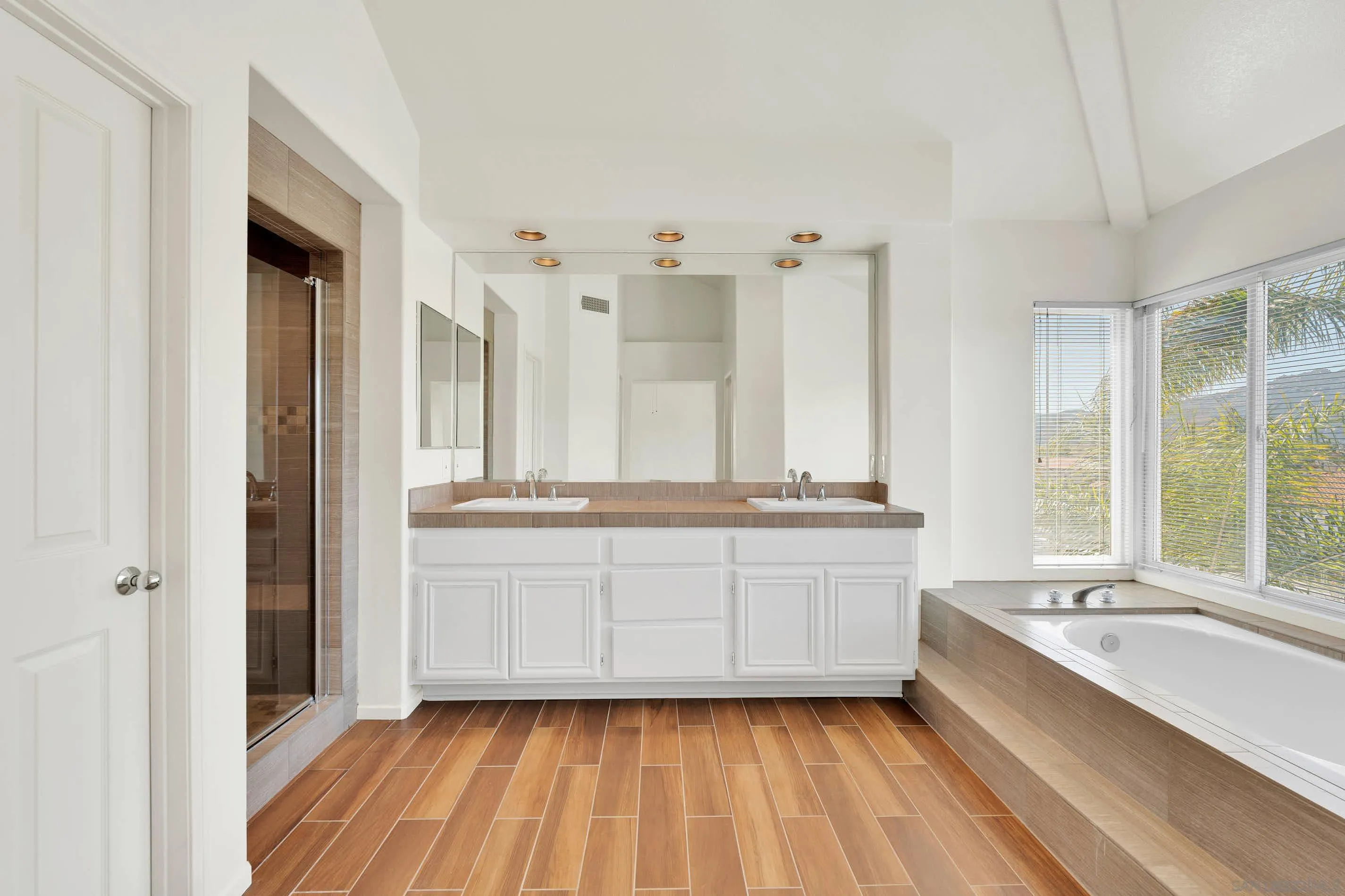 45441 Camino Monzon Temecula, CA 92592 - Photo 34 of 53 a bathroom with a double vanity sink a mirror and a bathtub