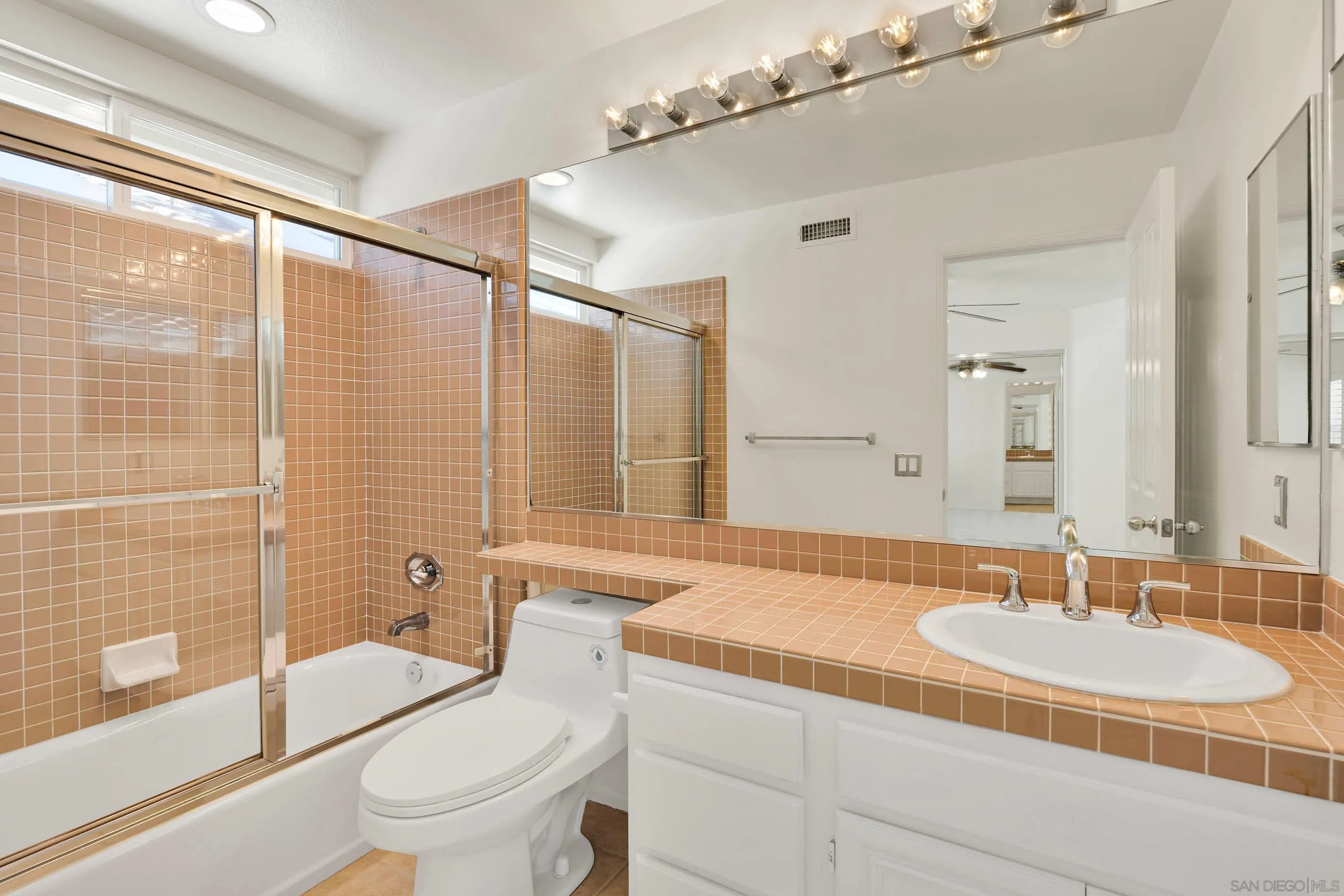 45441 Camino Monzon Temecula, CA 92592 - Photo 45 of 53 a bathroom with a granite countertop sink a toilet a mirror and shower