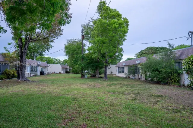 a view of a house with a yard and tree s