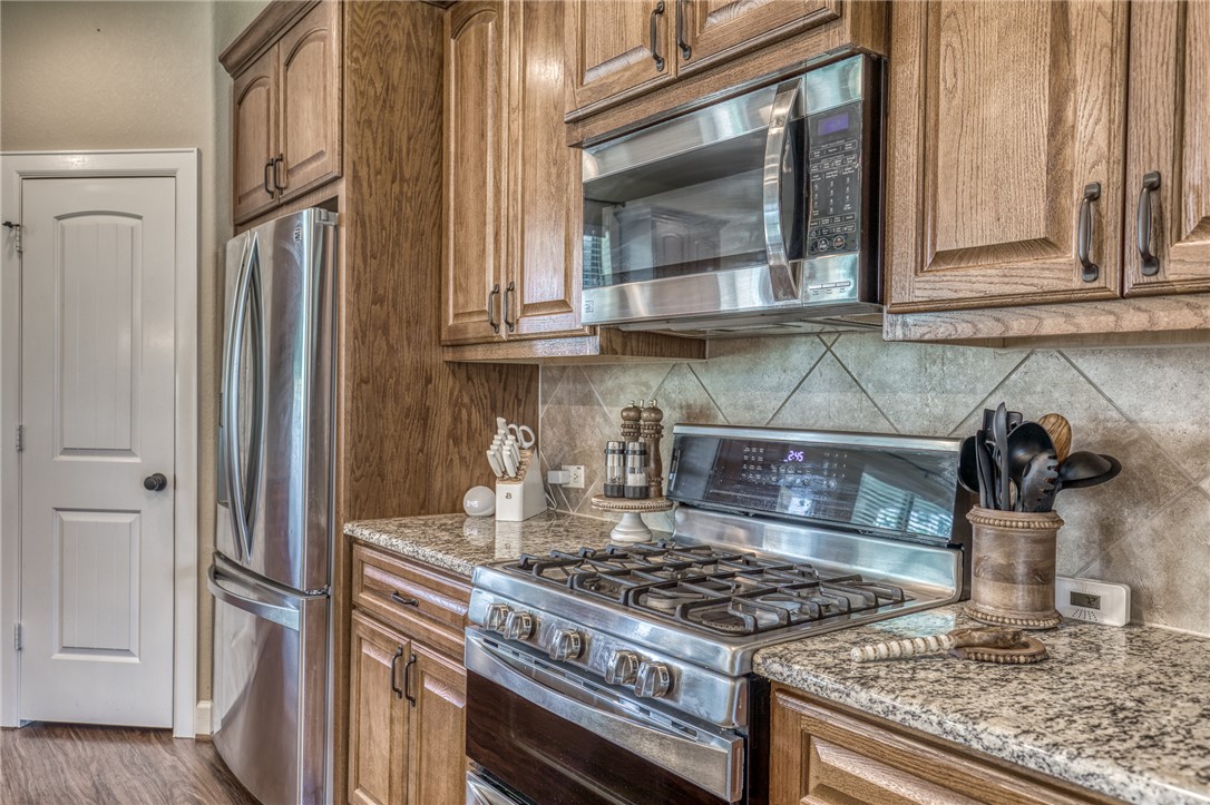 586 Ruby Drive Bellville, TX 77418 - Photo 14 of 50 a kitchen with stainless steel appliances granite countertop a stove and a microwave