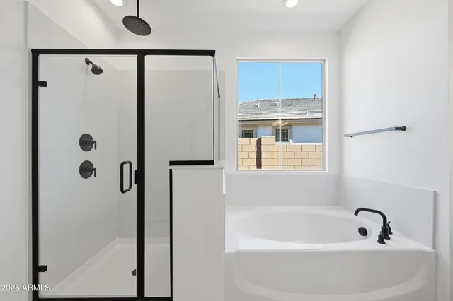 a spacious bathroom with a double vanity sink a mirror and a bathtub