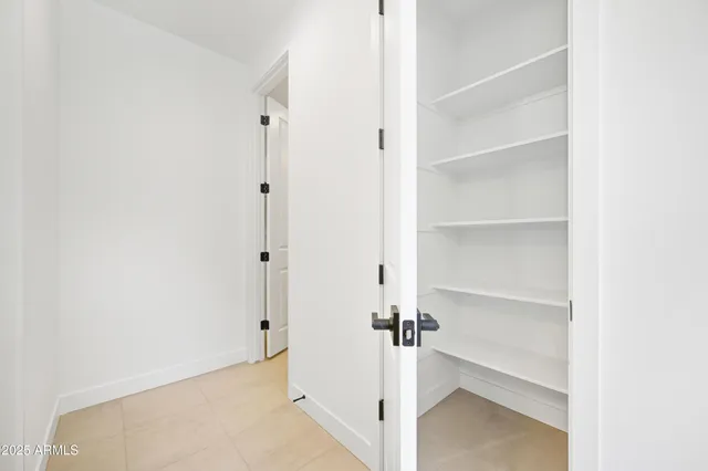 an empty room with entrance and windows