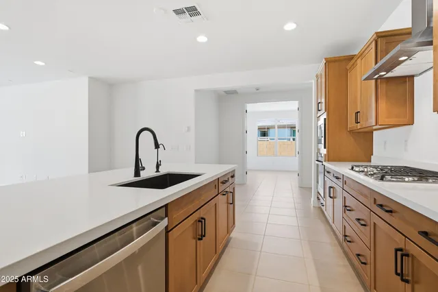 a large kitchen with stainless steel appliances and a refrigerator