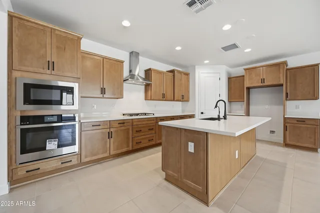 a kitchen with stainless steel appliances granite countertop a sink a stove and white cabinets