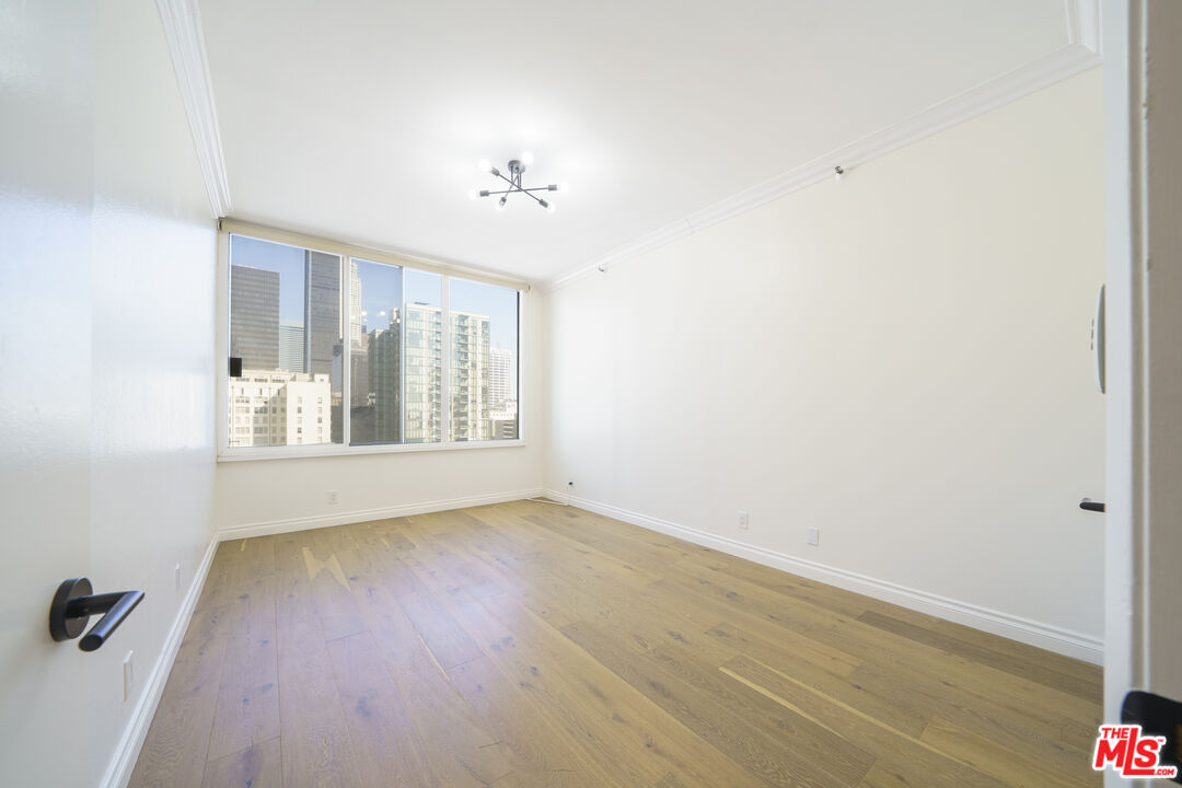 600 West 9th Street, Unit 1502 Los Angeles, CA 90015 - Photo 14 of 37 an empty room with wooden floor and windows