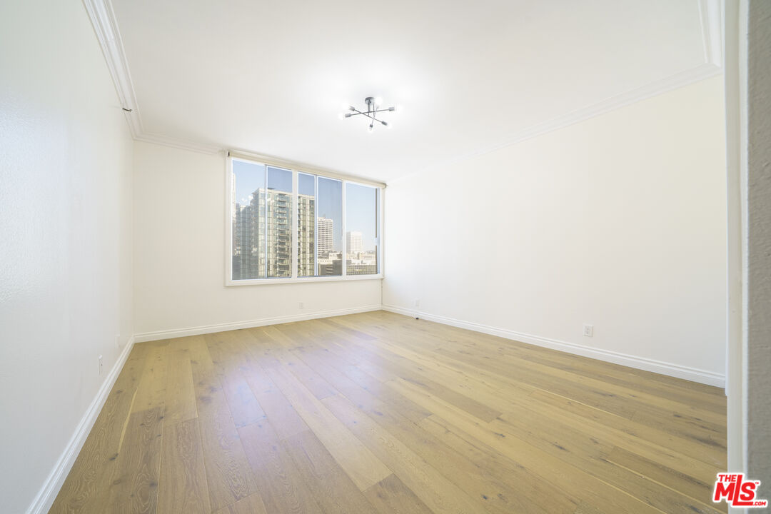 600 West 9th Street, Unit 1502 Los Angeles, CA 90015 - Photo 18 of 37 a view of an empty room with wooden floor and a window