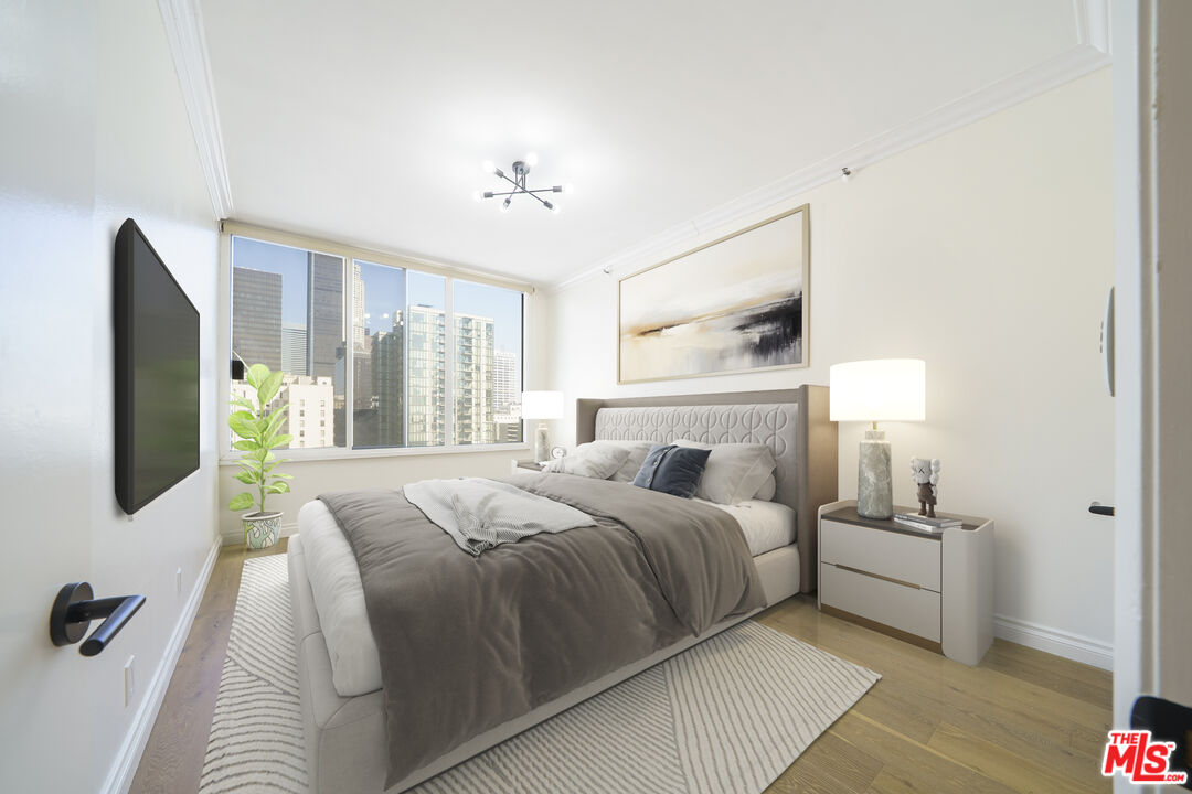 600 West 9th Street, Unit 1502 Los Angeles, CA 90015 - Photo 26 of 37 a bedroom with a large bed and a flat tv screen on a dresser