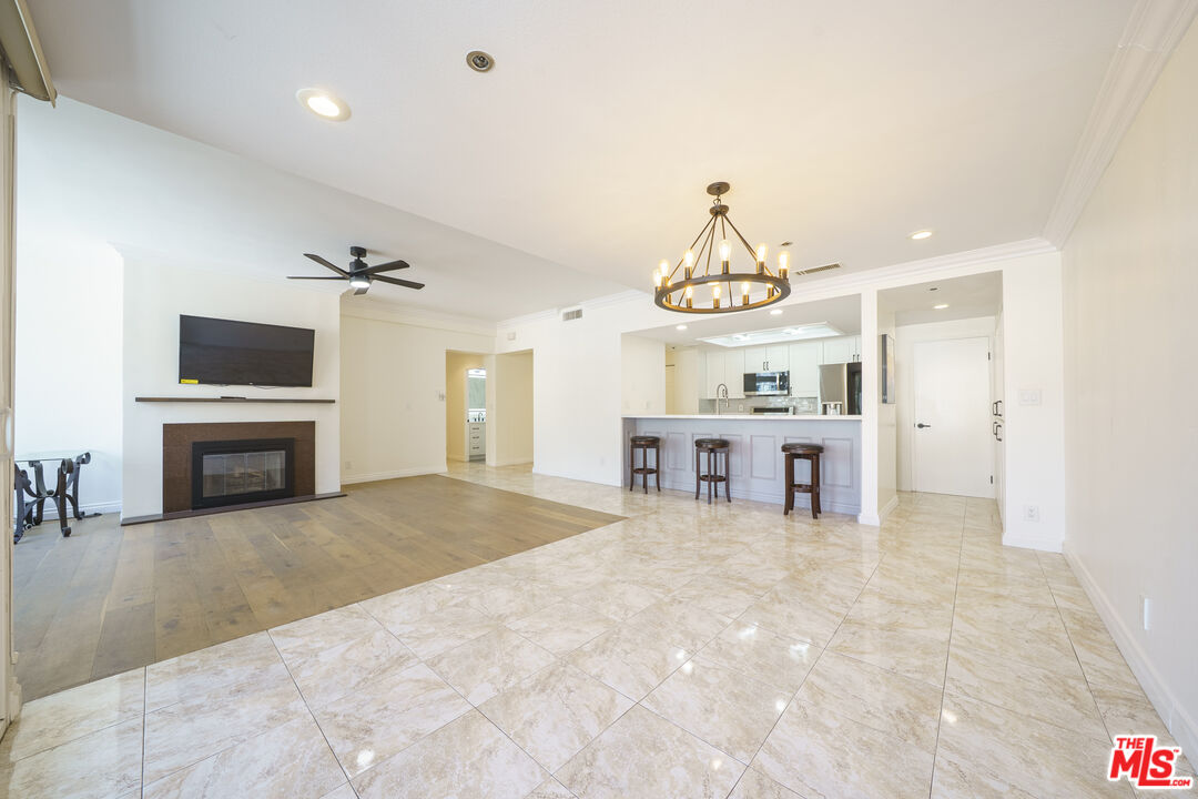 600 West 9th Street, Unit 1502 Los Angeles, CA 90015 - Photo 10 of 37 a living room with furniture a fireplace and a chandelier