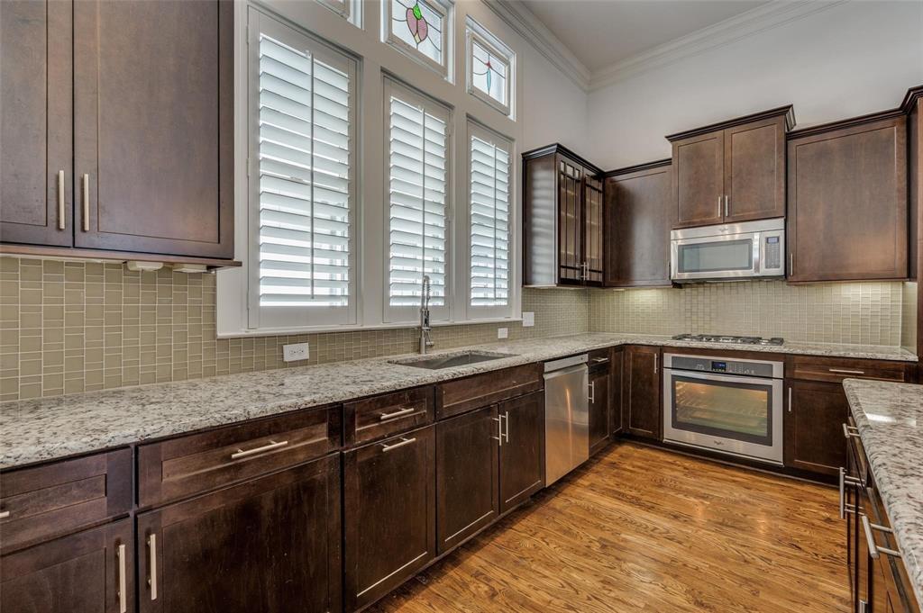 2135 Marilla Street Dallas, TX 75201 - Photo 10 of 23 a kitchen with stainless steel appliances granite countertop wooden cabinets a sink and a stove