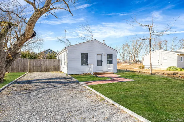 a white house with a small yard and wooden fence