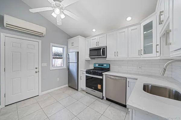 a kitchen with cabinets stainless steel appliances and sink