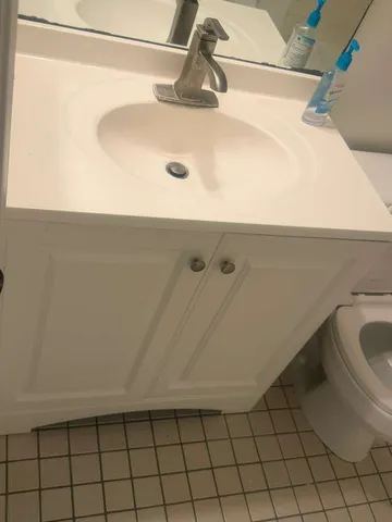 a kitchen with granite countertop white cabinets and a sink