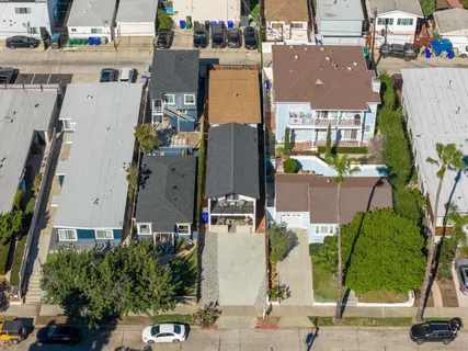 an aerial view of residential houses with outdoor space and parking