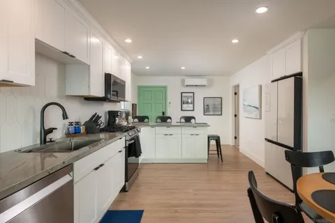 a kitchen with white cabinets and appliances