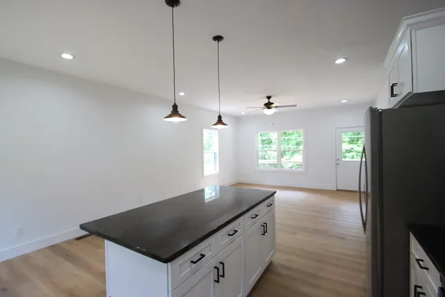 a kitchen with granite countertop a stove a sink and a refrigerator