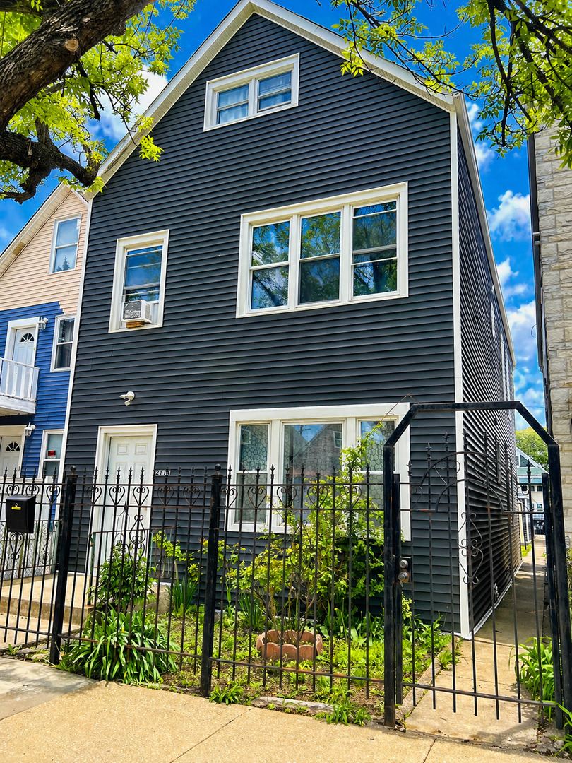 2114 West 51st Street, Unit 1 Chicago, IL 60609 - Photo 1 of 9 a front view of a house with a garden