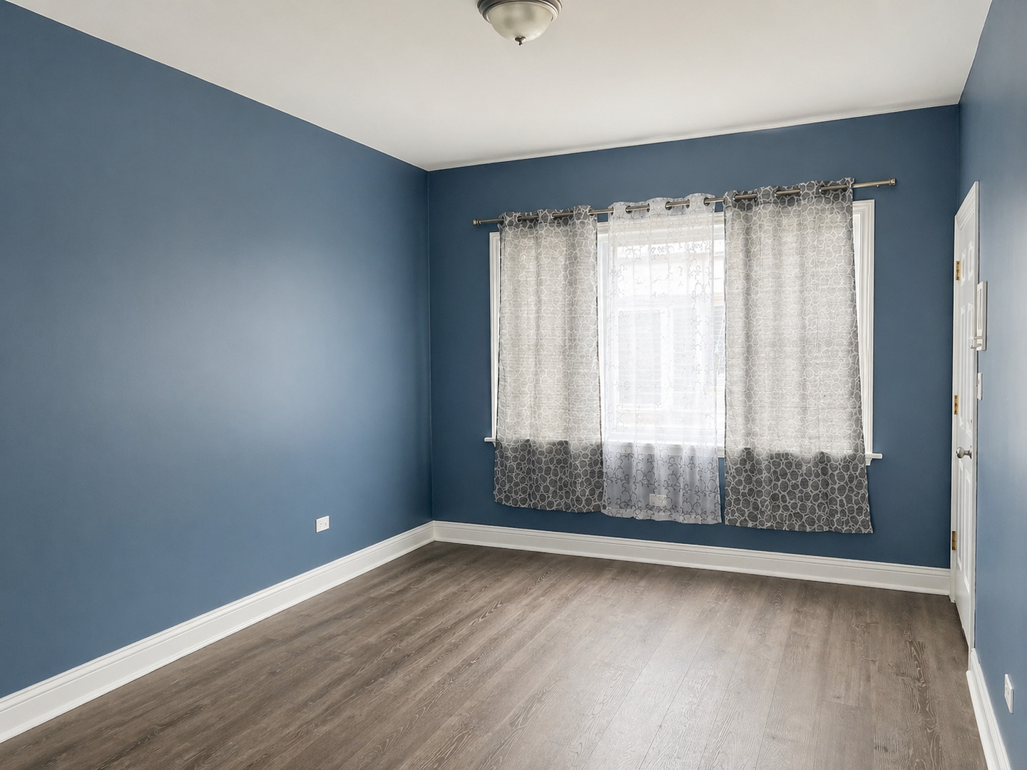 2114 West 51st Street, Unit 1 Chicago, IL 60609 - Photo 3 of 9 wooden floor in an empty room with a window