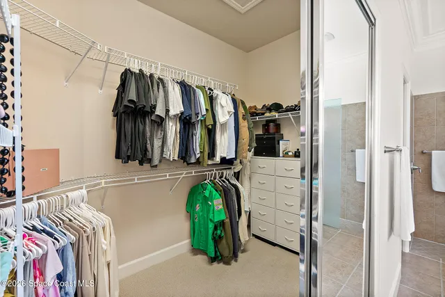 a view of walk in closet with clothes and shoes