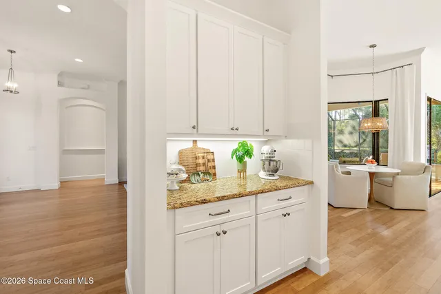 a dining area with stainless steel appliances kitchen island granite countertop a dining table chairs and a refrigerator