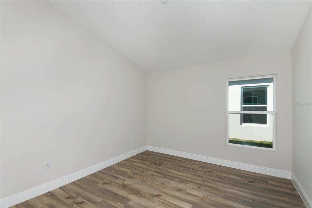 6103 Southwest 97th Street Ocala, FL 34476 - Photo 18 of 26 a view of empty room with wooden floor and fan