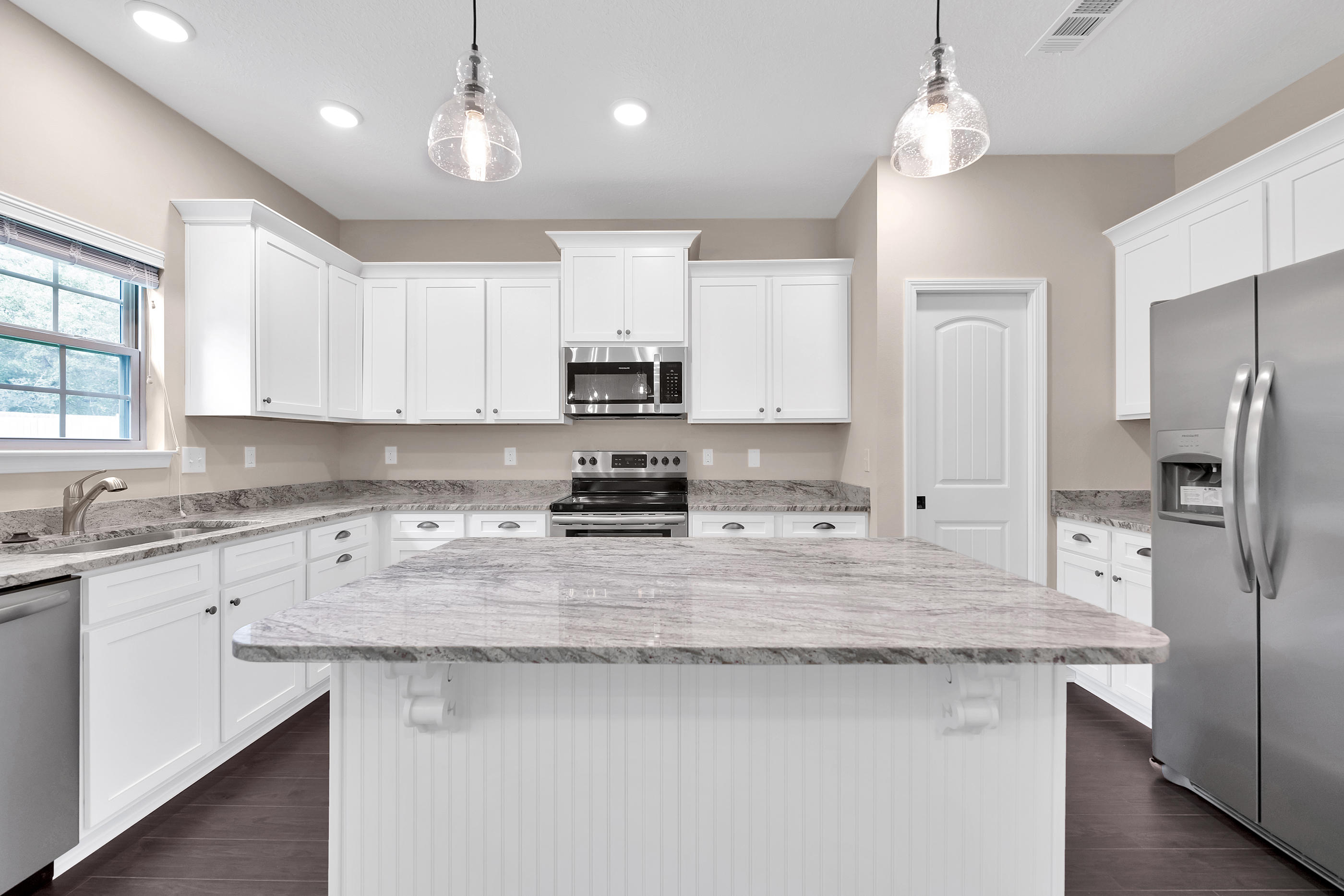 6198 Timberland Ridge Drive Crestview, FL 32539 - Photo 16 of 37 a kitchen with stainless steel appliances granite countertop a sink a stove a refrigerator cabinets and chairs