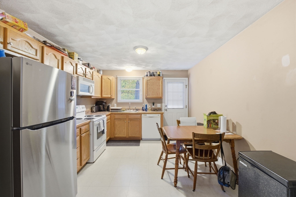 248-252 Church Street Burrillville, RI 02859 - Photo 12 of 26 a kitchen with a refrigerator a table and chairs
