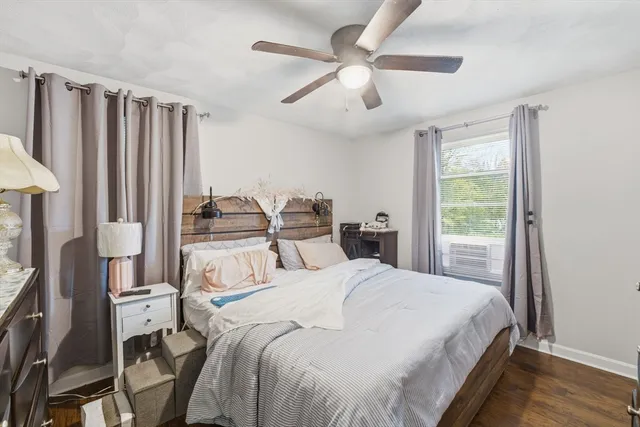 a spacious bedroom with a bed a couch and a large window