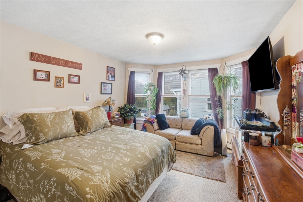 248-252 Church Street Burrillville, RI 02859 - Photo 17 of 26 a spacious bedroom with a bed a couch and a large window