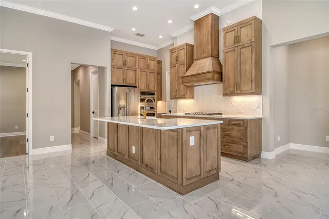 a kitchen with a refrigerator and a stove top oven