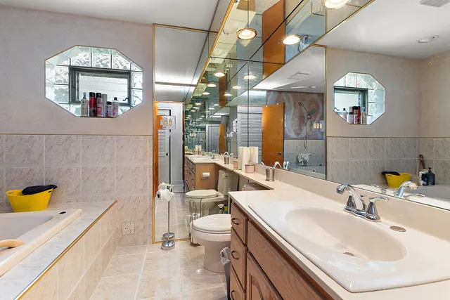 a bathroom with a tub a sink and a mirror