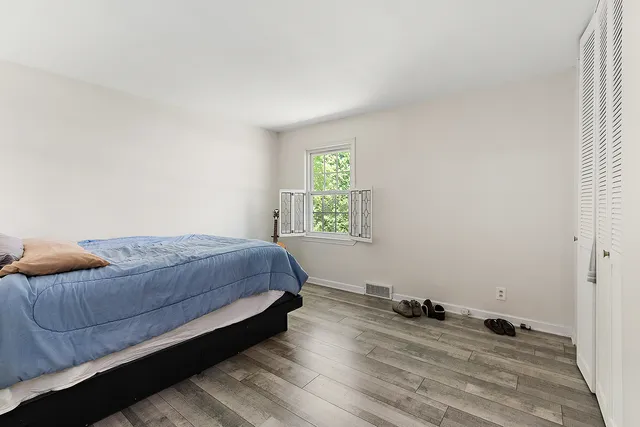 a bedroom with a bed and wooden floor