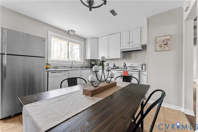 a kitchen with stainless steel appliances granite countertop a sink refrigerator and cabinets